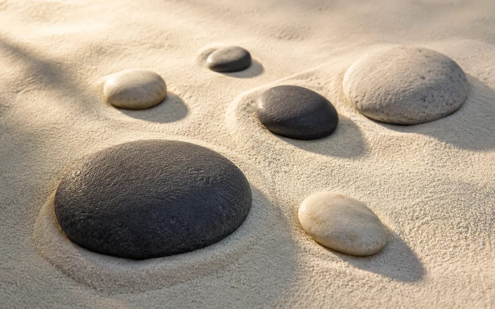 Des galets disposés sur du sable clair